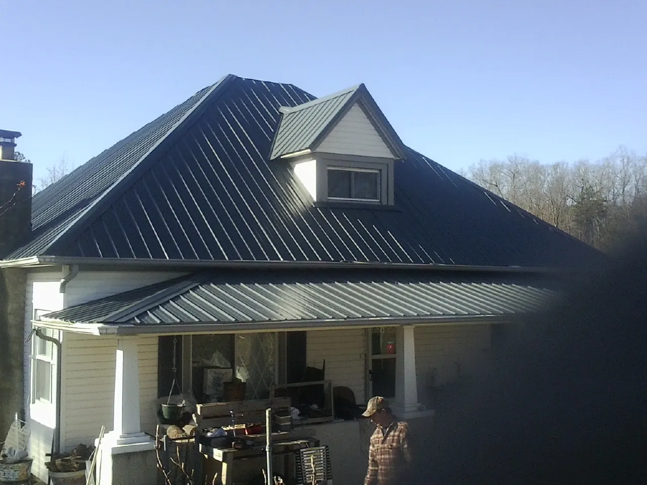 Dark blue standing seam metal roof with a dormer above a front porch in South Richmond Hill