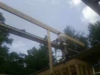 Carpenter setting a ridge beam over a new addition frame — Ice Dam Removal by Roofing Brothers in South Richmond Hill