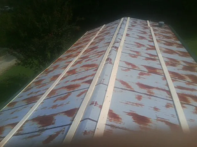 Rusted metal roof panels with new wood purlins before replacement — Storm Damage Roof Repair in South Richmond Hill by Roofing Brothers